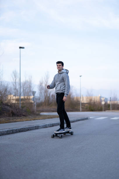 istock Man on a electric skateboard on an empty road 1208822717