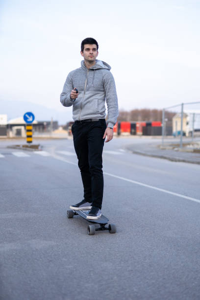 istock Man on a electric skateboard on an empty road 1208822806