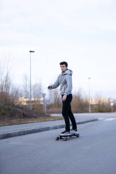 istock Man on a electric skateboard on an empty road 1208822837