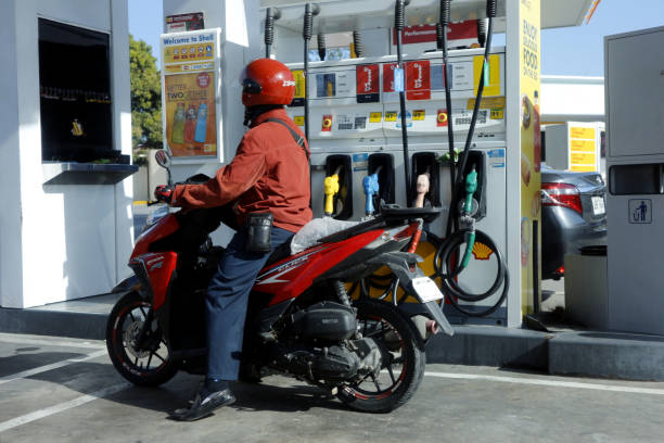 Motorcycle rider stops to refuel at a gas refilling station stock photo