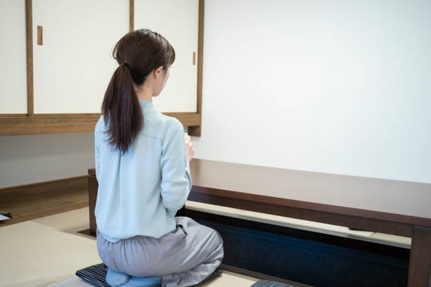 Back view of a young woman relaxing in a Japanese-style room Back view of a young woman relaxing in a Japanese-style room zabuton stock pictures, royalty-free photos & images
