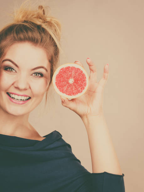istock Happy smiling woman holding red grapefruit 1208826875