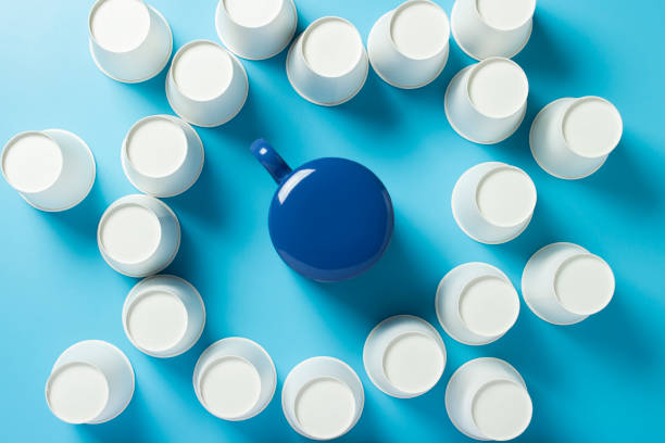istock Cup is surrounded by empty Paper cups for drinks on a blue background. Banner. Flat lay, top view 1208828453