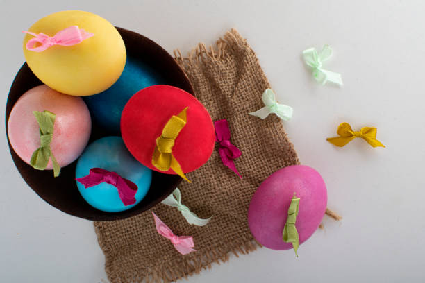 istock Colored eggs with bows in a bowl on a linen napkin. 1208830077