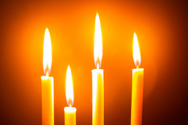 istock burning orange candles close up 1208832630