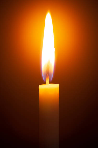 istock One light candle burning brightly in the black background 1208833824