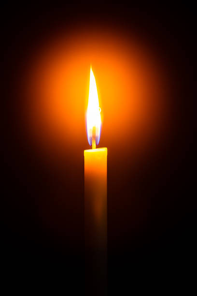 One light candle burning brightly in the black background