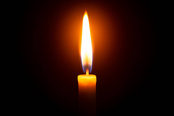 istock One light candle burning brightly in the black background 1208833916