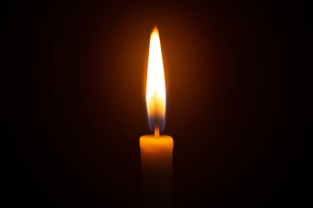 istock One light candle burning brightly in the black background 1208833943