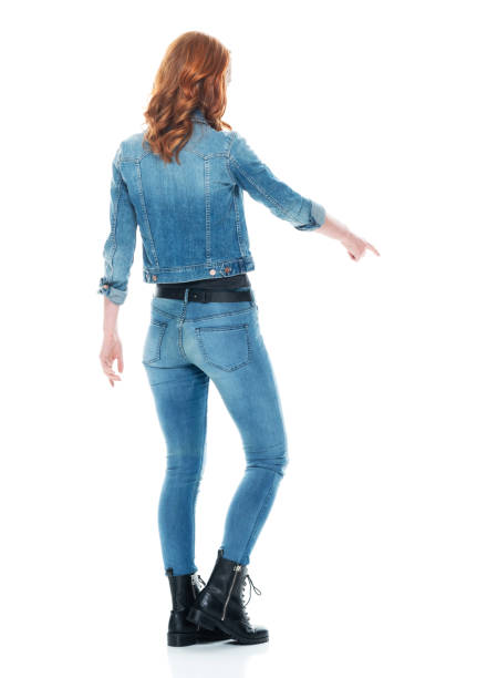 Caucasian young women standing in front of white background wearing jeans Full length of aged 20-29 years old who is beautiful with redhead caucasian young women standing in front of white background wearing jeans who is pointing double denim stock pictures, royalty-free photos & images