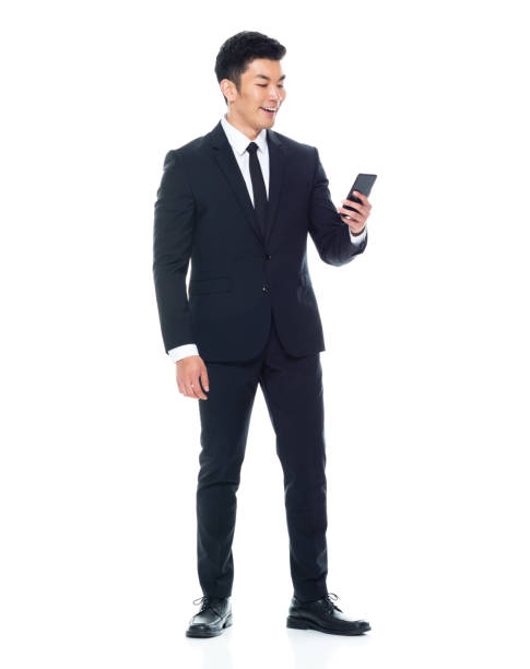 istock Chinese ethnicity young male manager standing in front of white background and using smart phone 1208834907