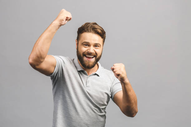 istock Happy winner. Happy young handsome man gesturing and keeping mouth open while standing against grey background. 1208834981