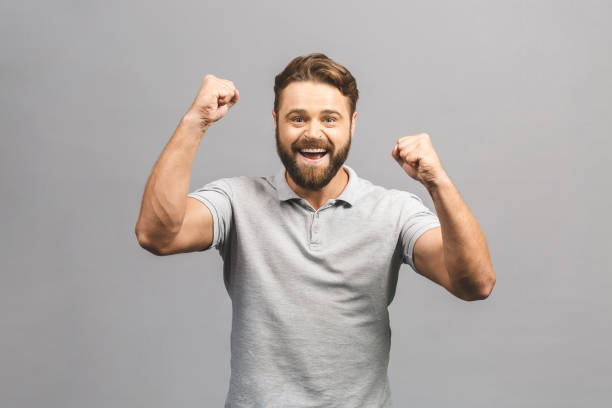 istock Happy winner. Happy young handsome man gesturing and keeping mouth open while standing against grey background. 1208834994