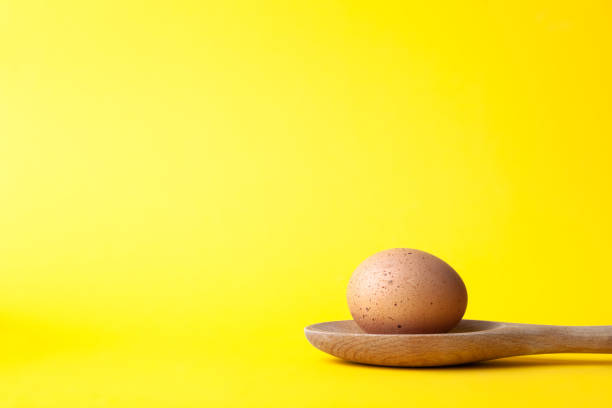 istock Easter egg on wooden spoon on yellow background 1208835847