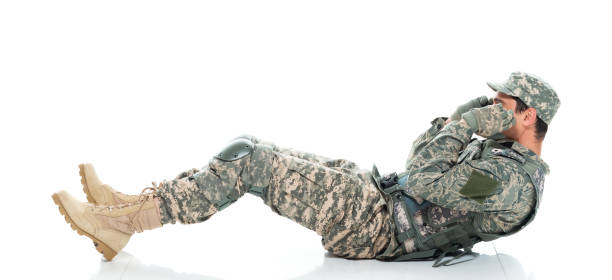 istock Caucasian young male armed forces doing sit-ups in front of white background in the us military wearing uniform and being active with sports training 1208837332