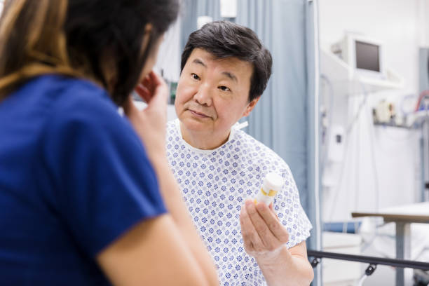 istock Senior man asks emergency room nurse about medication he holds 1208837612