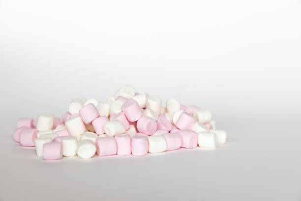 istock Pink and white mini marshmallows on white background, sweet food 1208839094