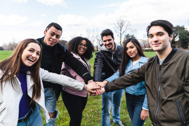 istock Group of teenagers stacking their hands together, making a team 1208839883