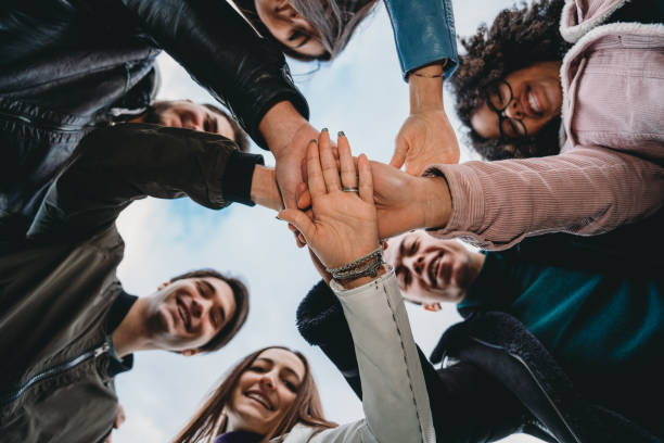 istock Group of friends showing unity, they are stacking their hands together 1208839899