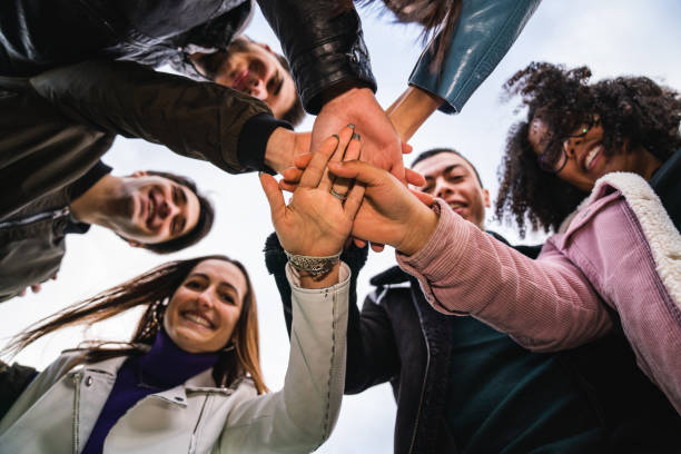 istock Group of friends showing unity, they are stacking their hands together 1208839907