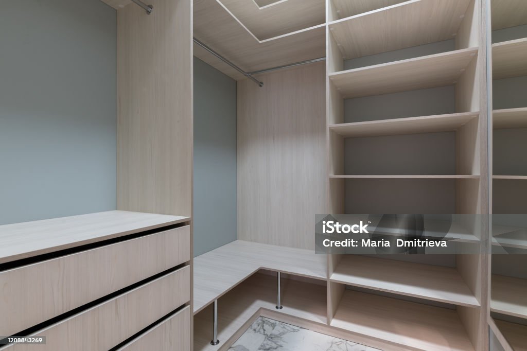 empty dressing room with wooden light furniture. dressing room, space distribution, furniture arrangement, convenient functionality. Customized Stock Photo