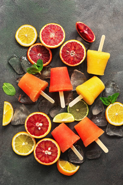 istock Assorted homemade frozen citrus juice. Popsicles from different oranges with ice and mint leaves. Summer dessert. Top view, flat lay. 1208843526