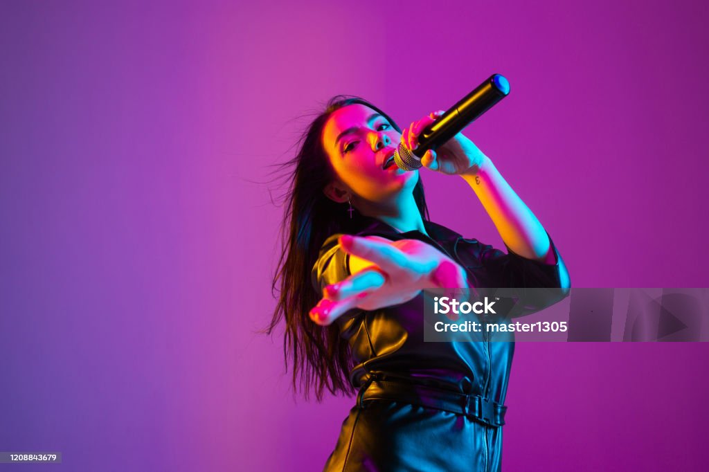 Caucasian Female Singer Portrait Isolated On Purple Studio Background In  Neon Light Stock Photo - Download Image Now - iStock