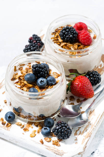 istock healthy creamy dessert with fresh berries on white background, vertical closeup 1208844644