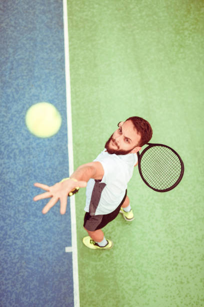 istock Athletic Male Serving Tennis Ball 1208846712