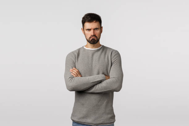 istock Offended grumpy cute bearded boyfriend feeling let down and displeased, standing insulted, partner hurt his feelings, cross arms chest defensive, make sad expression, standing angry white background 1208847399