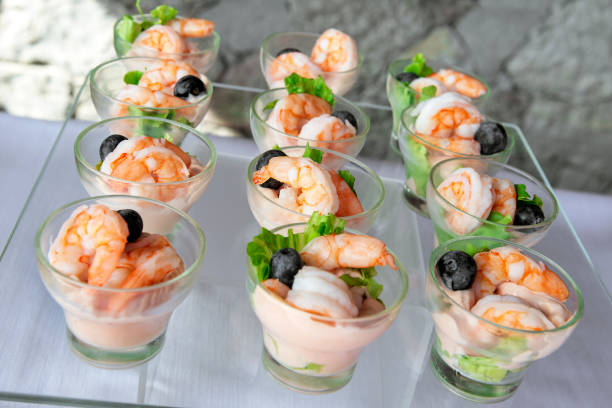 bandeja con porciones de colas de gambas en salsa de cóctel - canape buffet cocktail food fotografías e imágenes de stock