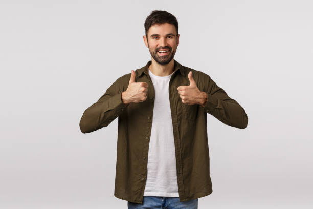 istock Good idea, supportive friend encourage take action, like idea. Attractive bearded man in coat, show thumbs-up and smiling approval, approve plan, recommend service, leave positive feedback 1208849099