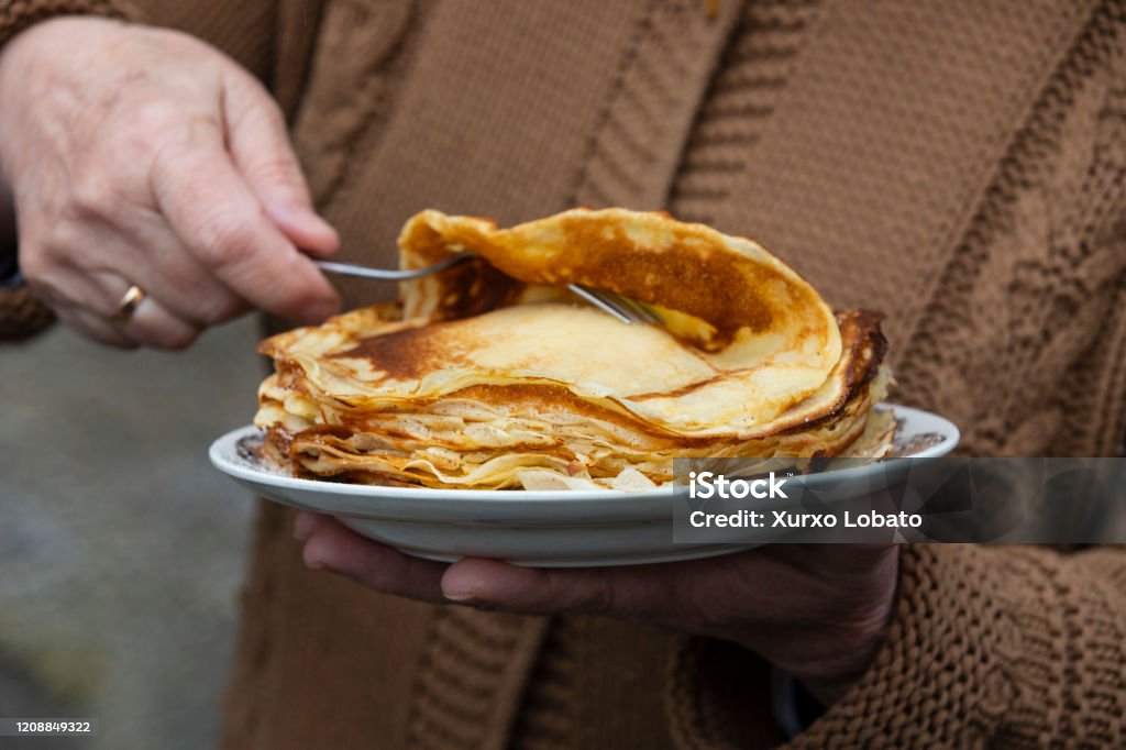 Filloas gastronomia of the Carnival of Galicia OURENSE, SPAIN - FEBRUARY 25:Filloas as it is called the crepes in Galician cuisine. At the party Pitas de Eiroas, inspired by chickens, is an original carnival in the Eiroas neighborhood of Ourense in seen February 25, 2020,  Ourense, Galicia,Spain.(Photo by Xurxo Lobato/Getty Images) Baked Pastry Item Stock Photo
