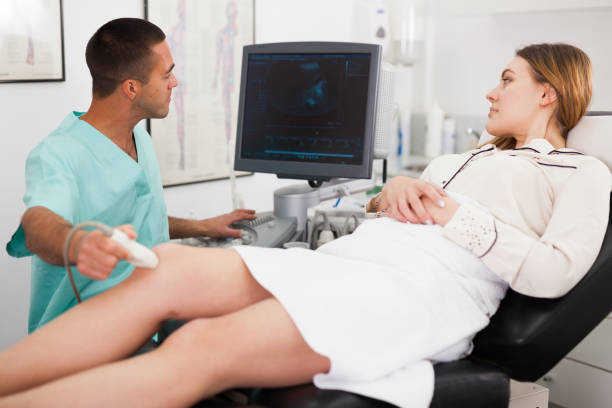 istock Man sonographer examining female patient 1208850788