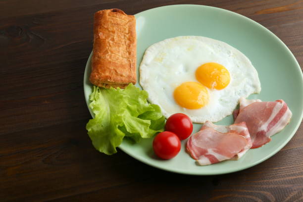 istock fried eggs are on the plate on dark wooden background 1208852290