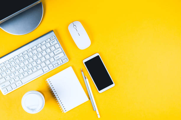 istock White keyboard, mouse and Notepad on yellow background. Flat lay and top view, copy space for text 1208853647
