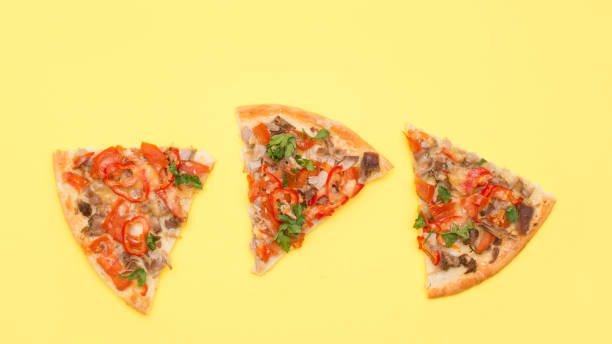 istock Three slices of pizza on a yellow background 1208854209