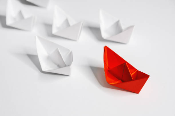 istock Leadership. Unique Paper Boat Leading The Rest. 1208854745
