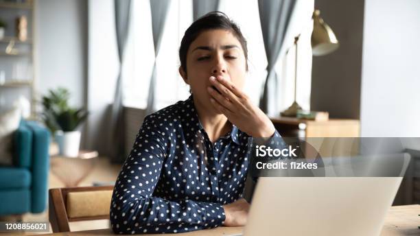 Tired Ethnic Woman Yawn Sigh At Workplace Stock Photo - Download Image Now - Working, Boredom, Yawning