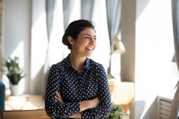 istock Smiling indian girl look in distance dreaming visualizing 1208856044