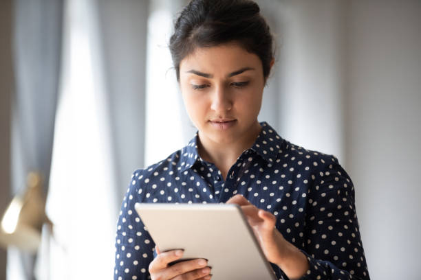istock Millennial indian girl using modern tablet gadget texting 1208856046