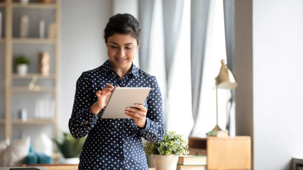 istock Happy ethnic girl using modern tablet device with wireless internet 1208856053