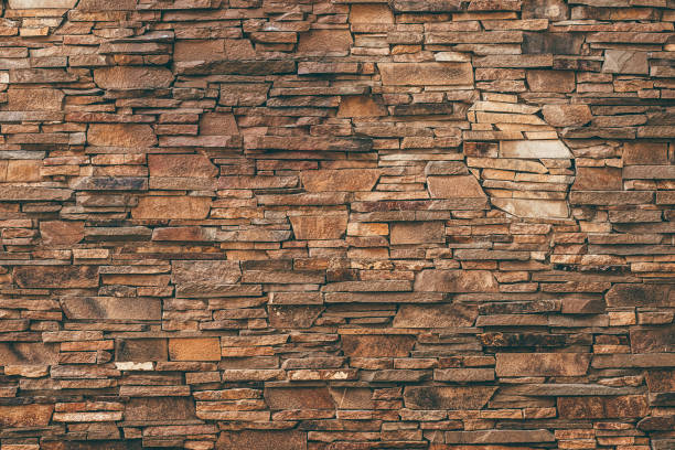 istock Abstract pattern of brown stone texture. Brick wall background. Rough granite surface. Cracked rock. Decorative tile on facade of building. 1208857704