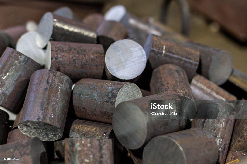 a pile of raw steel short rods cutted by saw- workpieces prepaired for forging, close-up with selective focus a pile of raw steel short bars cutted by saw- workpieces prepaired for forging, close-up with selective focus and background blur Ingot Stock Photo