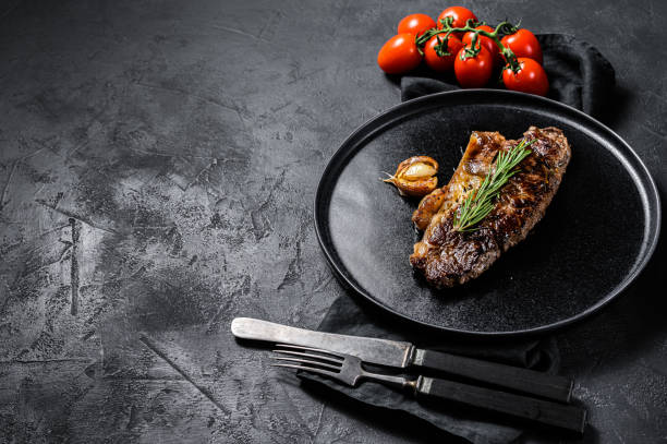 istock Beef strip loin steak on black background. Space for text. Marble beef. 1208865185