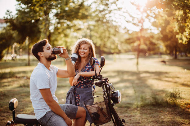 couples heureux sauvant le système d’éco - motorcycle motor scooter couple young adult photos et images de collection