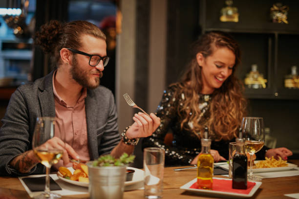 istock Group of friends sitting in restaurant and eating dinner. 1208865262