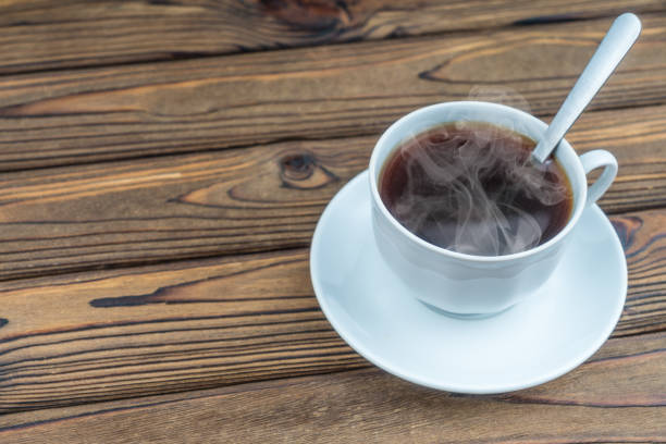 istock Cup of hot coffee on a wooden table background. 1208866639