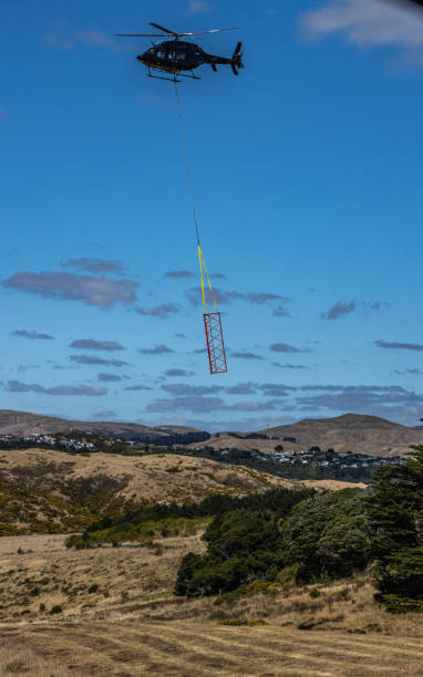 Helicopter lowering mast component into place stock photo