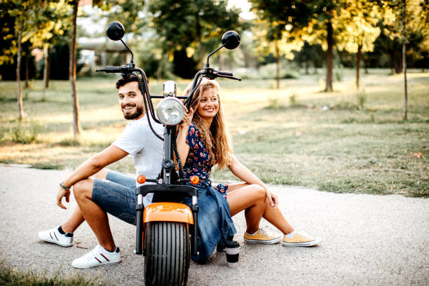 nous allons fonctionner sur des batteries - motorcycle motor scooter couple young adult photos et images de collection